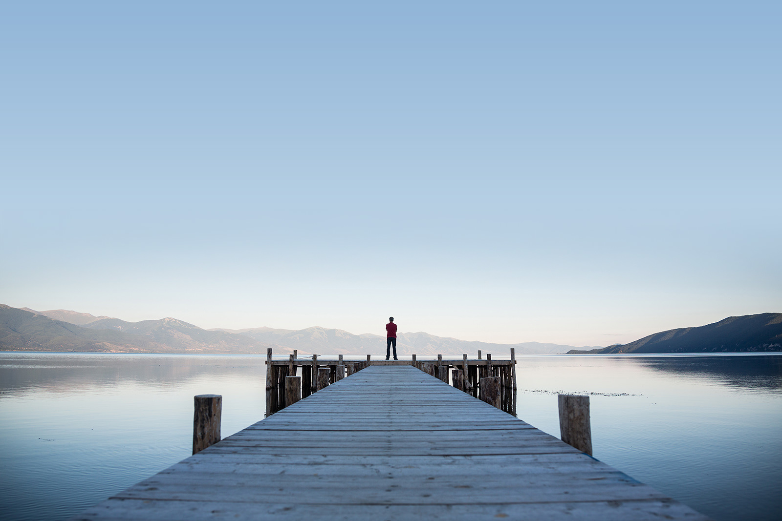 Holzweg ade – Mann auf Holzsteg blickt in die Ferne